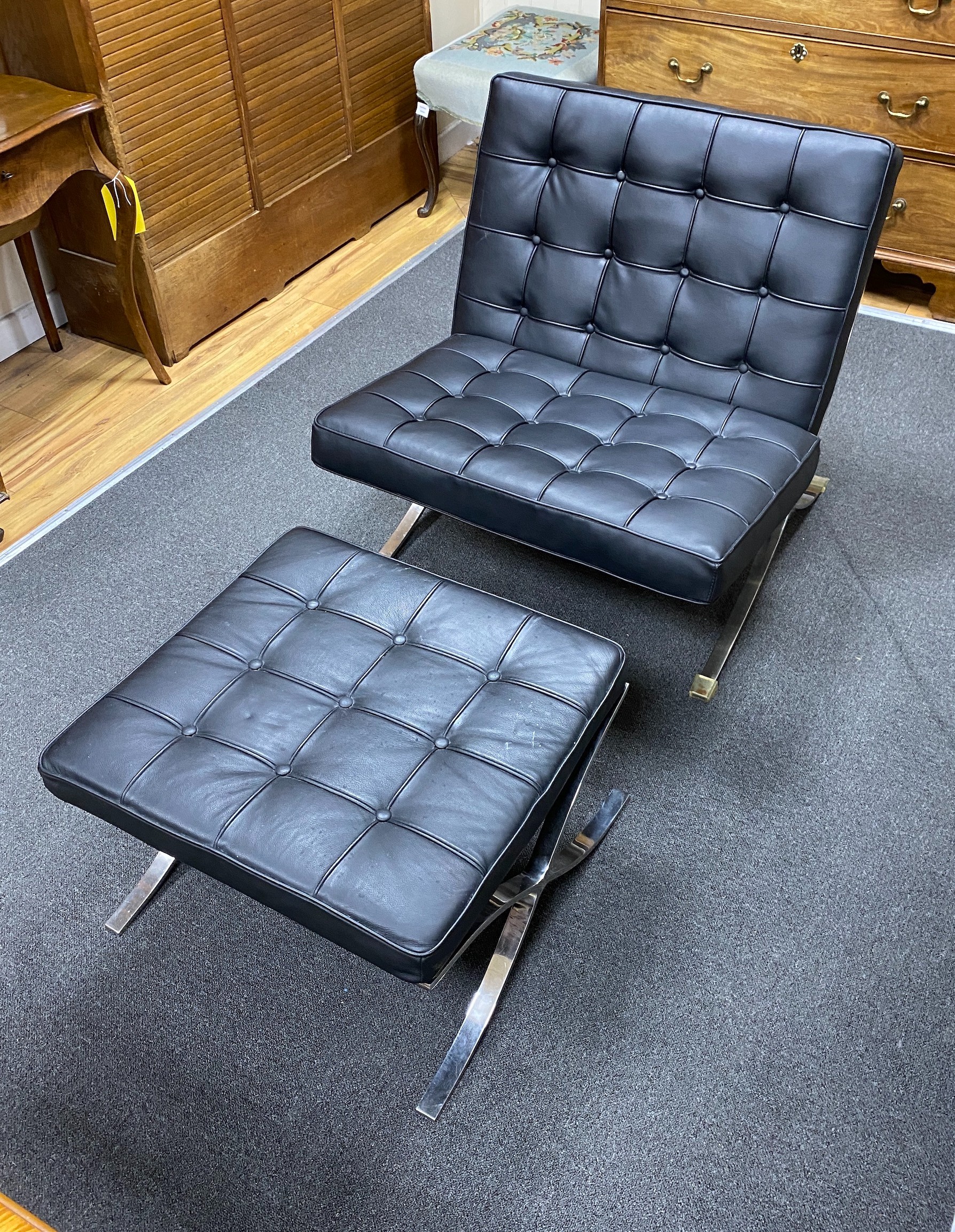 A black leather Barcelona chair, width 77cm, depth 32cm, height 80cm and an ottoman